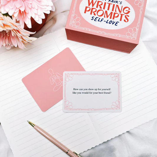 Writing prompts self-love card set with a pen and flowers on a marble surface