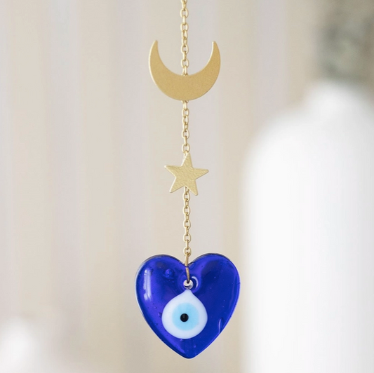 Decorative hanging charm with blue heart, gold crescent moon, and star on a light background