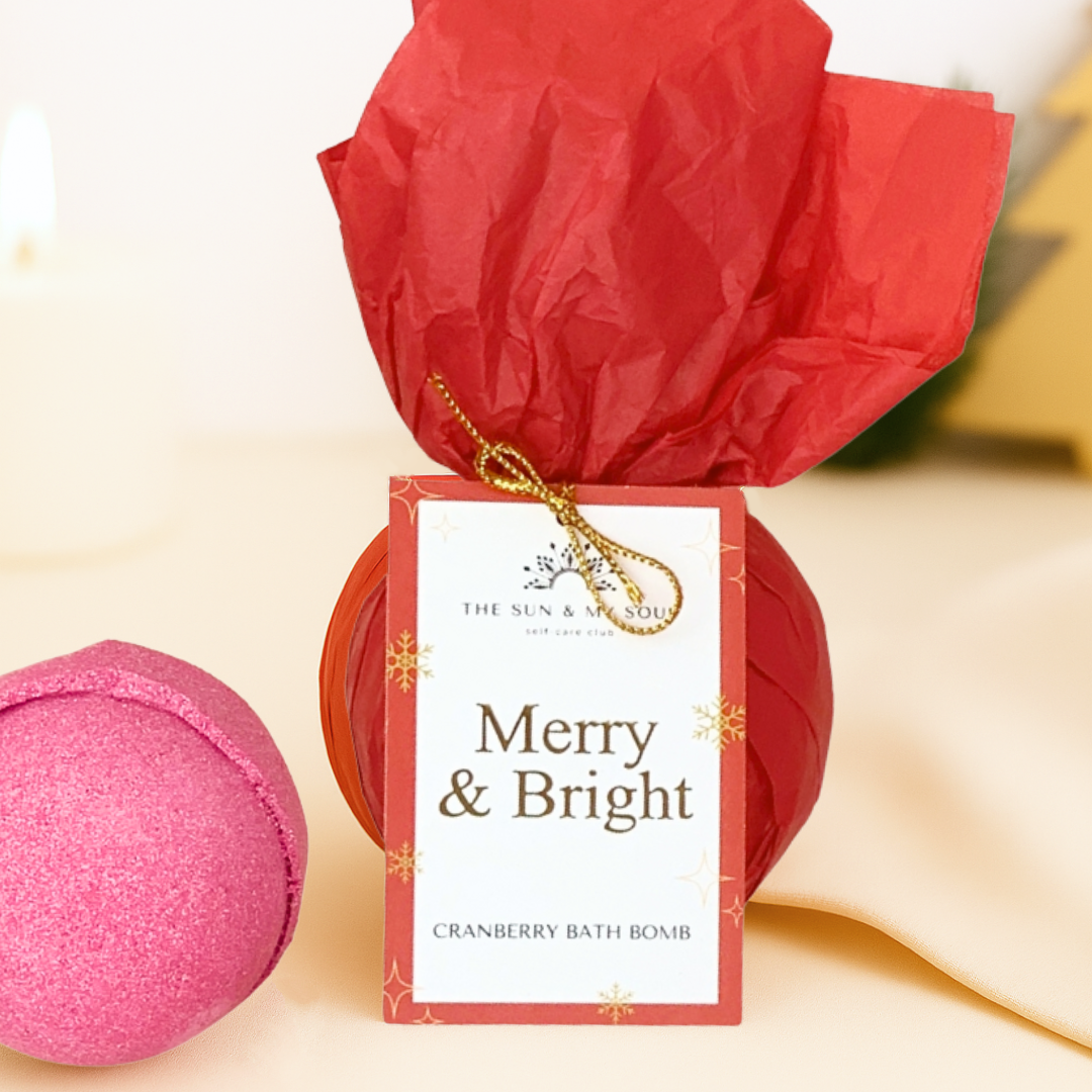 Red bath bomb with a 'Merry & Bright' label on a beige background