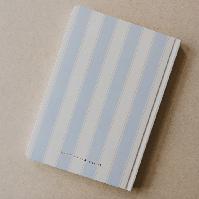 Notebook with blue and beige striped cover on a beige background