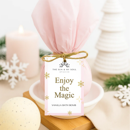 Vanilla bath bomb with a decorative tag on a white surface with candles and snowflake decorations.