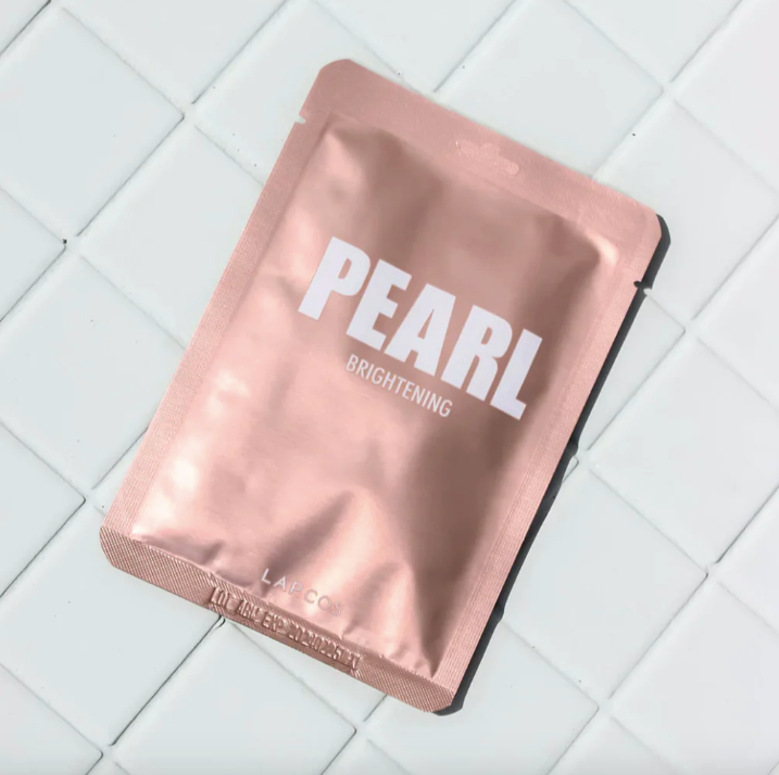 Pink sheet mask with 'Pearl Brightening' text on a white tiled background