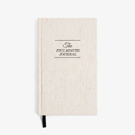 Beige journal with 'The Five Minute Journal' text on a white background