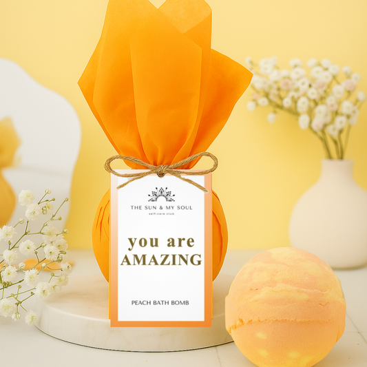 Peach bath bomb with 'you are amazing' packaging on a yellow background